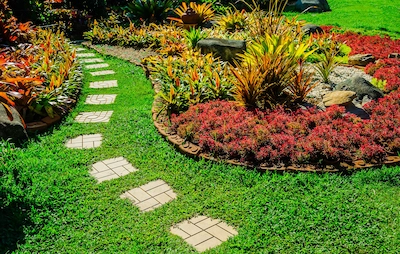 Landscaped exterior with path surrounded by flowers.
