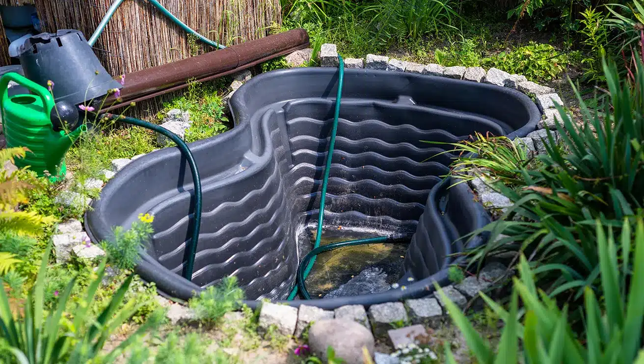 A newly installed pond being filled with water.