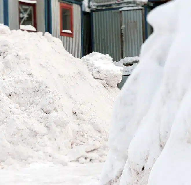 Tall piles of snow moved off a walkway.