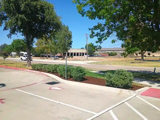 Mulch bed and shrubs installed by The Grounds Guys of Frisco at a fast food restaurant.