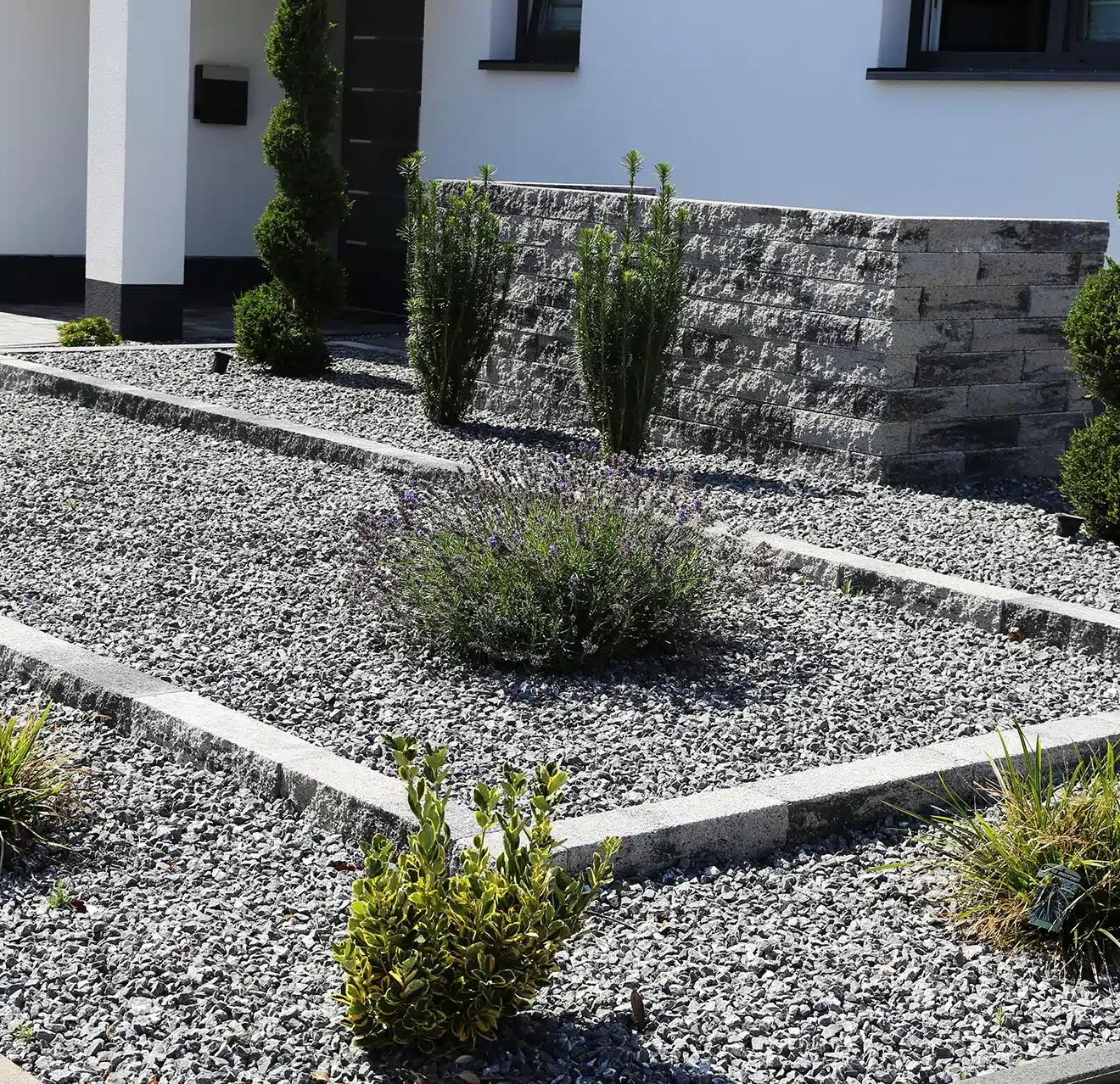 Decorative gravel and arid plants installed in a home's front yard.