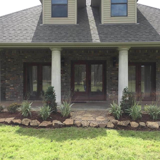 A house with grass yard and gardens