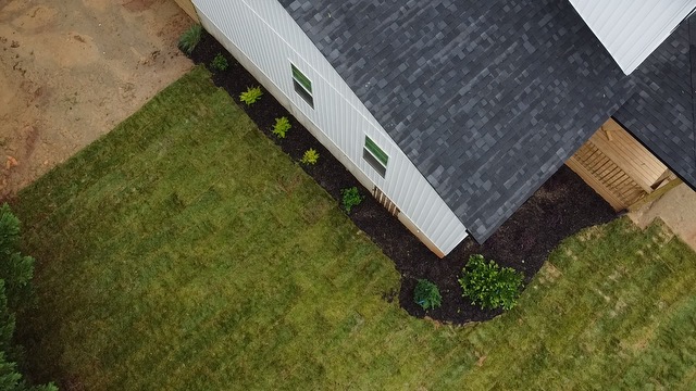 Perfect arial view of a fresh sod install, simple front entrance landscape install, and a side entry deck build.