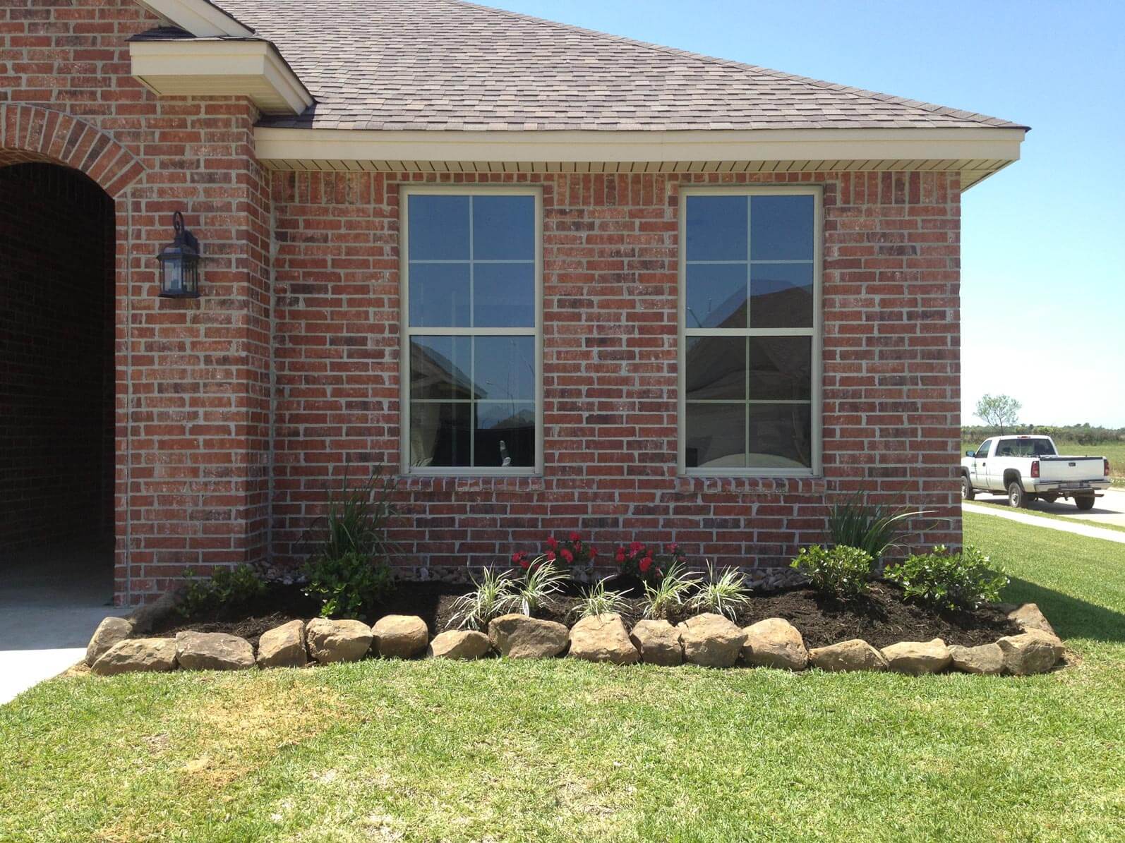 Grass yard in front of brick house