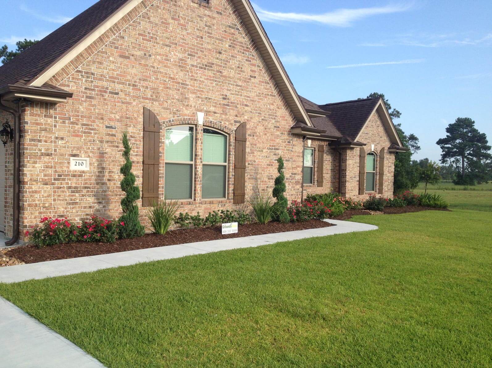 Side view of grass yard in front of brick house