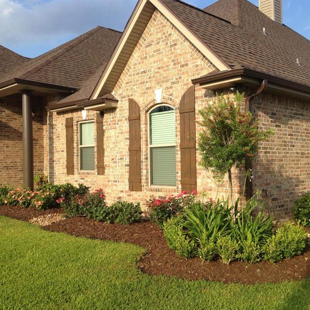 Side view of lawn and garden front of brick house