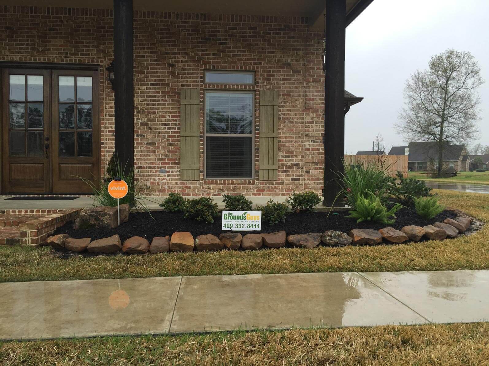 Soil and stone landscape in front of brick house