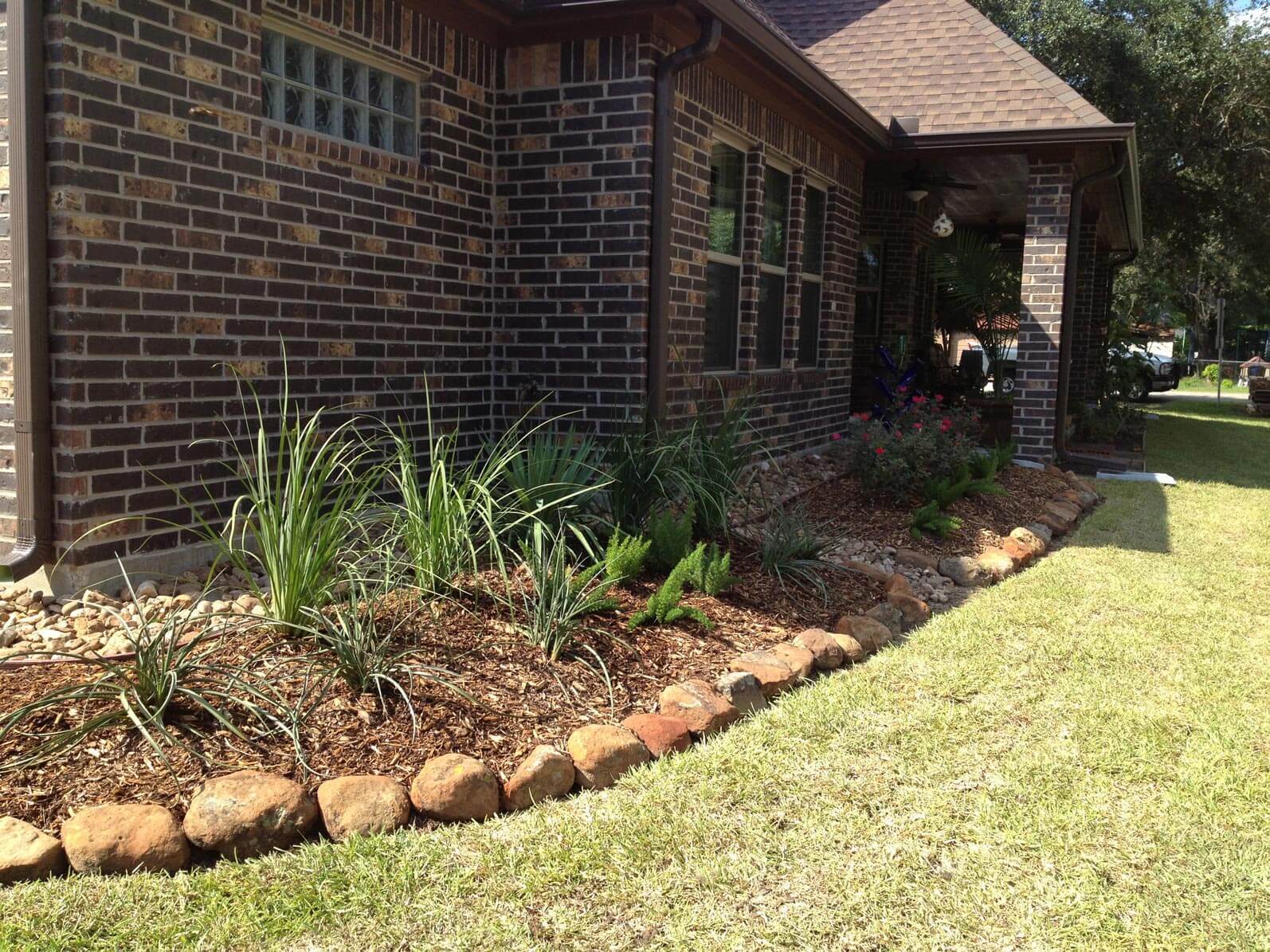 Soil and stone landscape on side of brick house