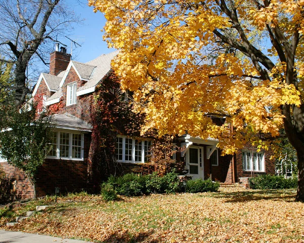 a greater little rock brick home with leaves fallen on lawn