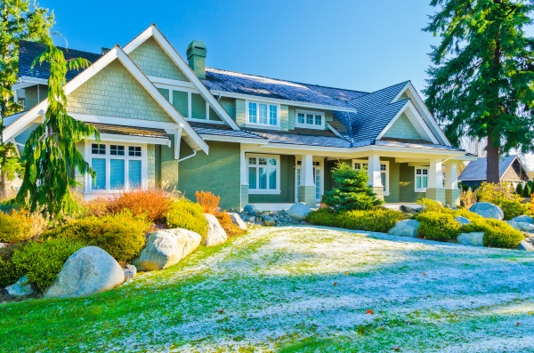 Beautifully landscaped residential home, with patches of snow covering the front lawn.
