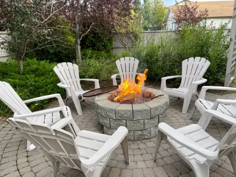 Chairs surrounding a backyard fire pit.
