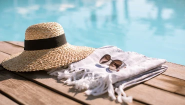 Straw hat and sunglasses sitting by a pool | The Grounds Guys of Gettysburg