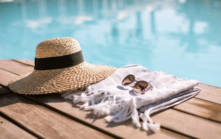 Straw hat and sunglasses sitting by a pool | The Grounds Guys of Gettysburg