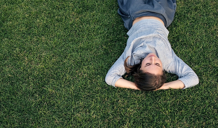 Woman laying on green grass