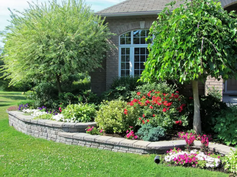 Flower bed in front yard with raised stone border