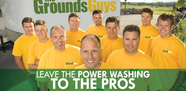 The Grounds Guys employees with text: "Leave the power washing to the pros"