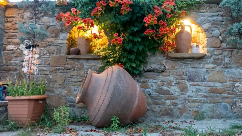 Pottery next to a stone retaining wall.