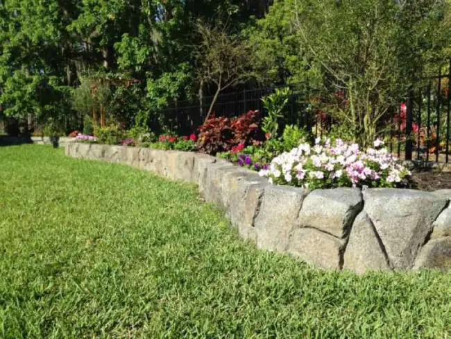 Landscaped stonework wall with green lawn
