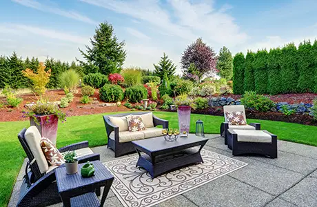 A gorgeous landscape and hardscape with patio and outdoor furniture.